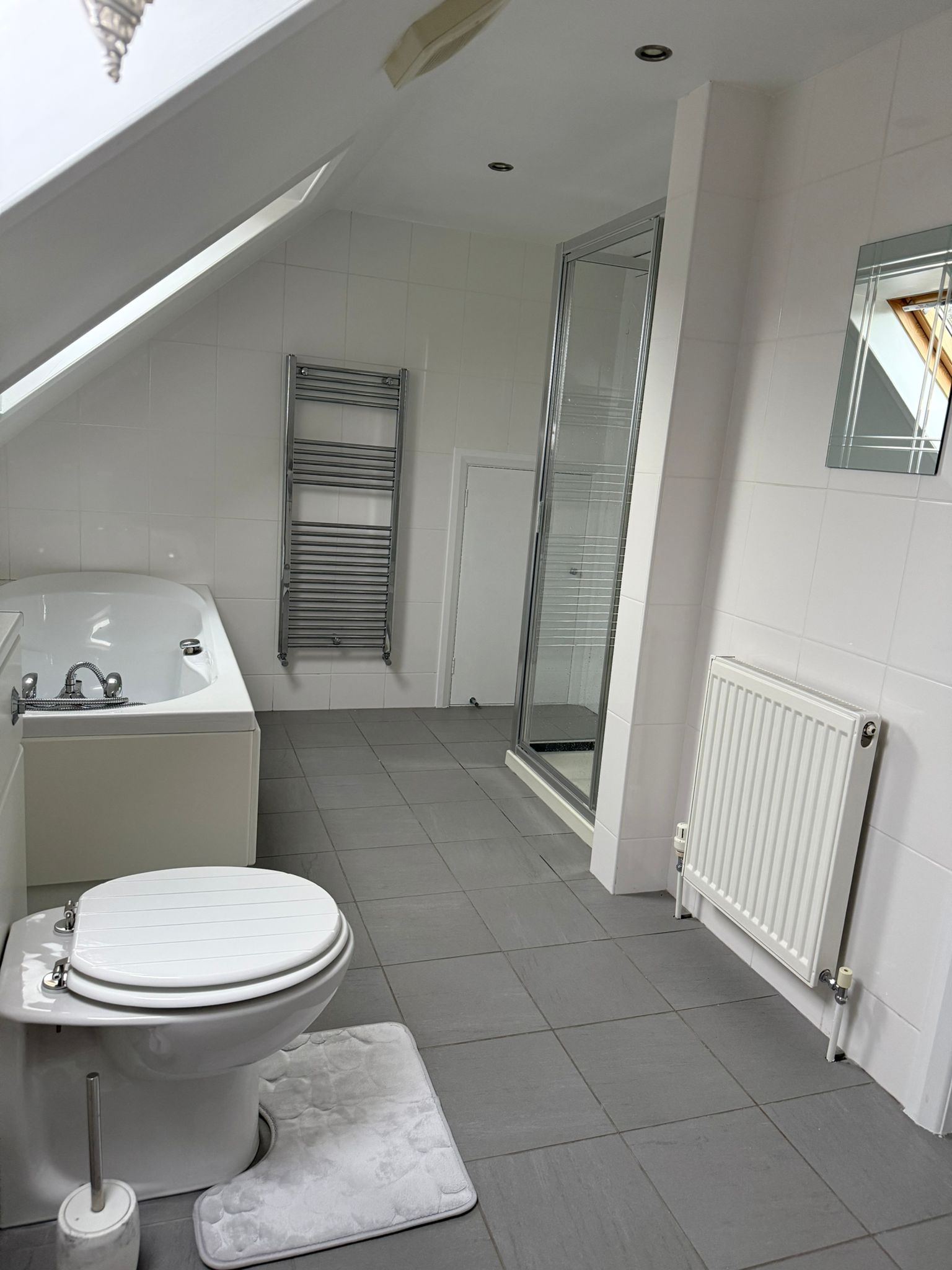 Bathroom perspective showing shower enclosure and radiator.