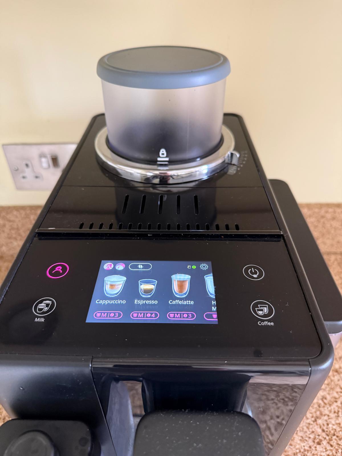 Coffee machine close-up with drink options on display.