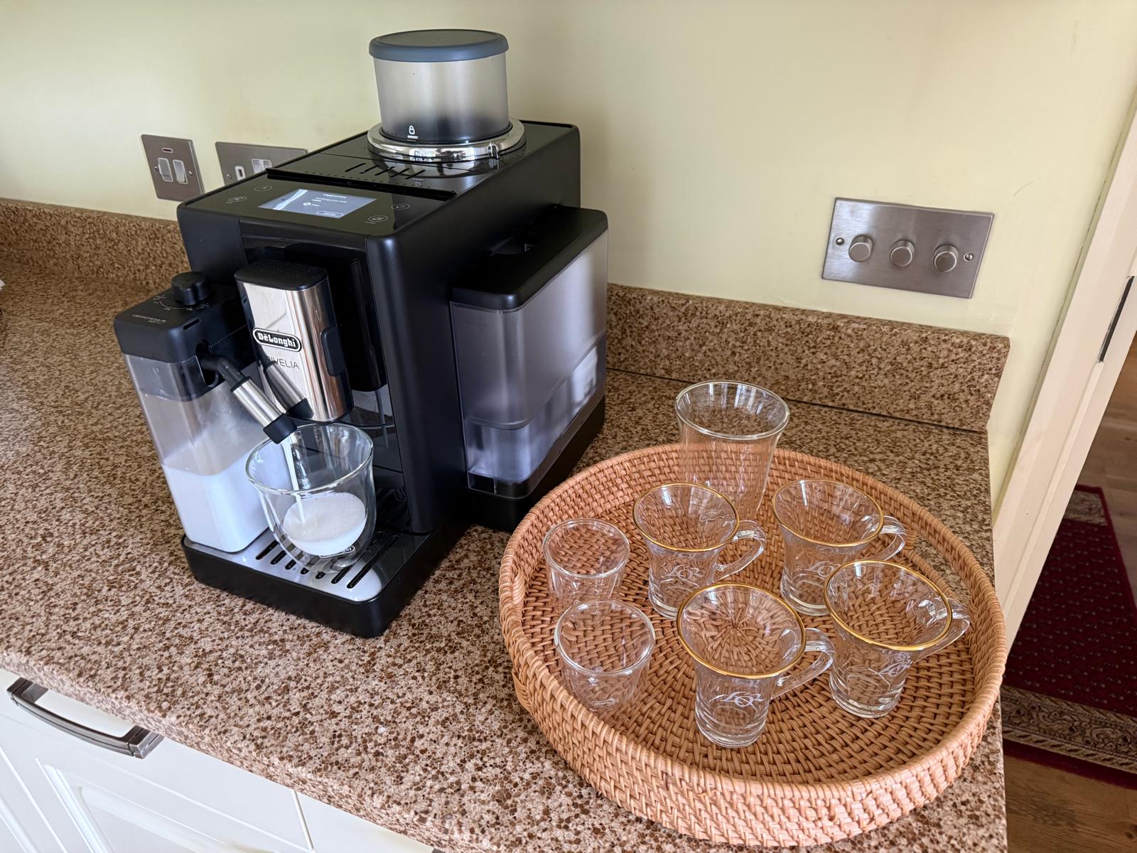 Coffee machine with glass cups and serving tray nearby.