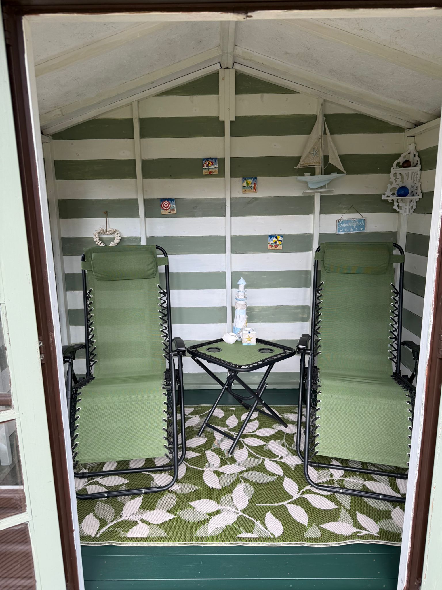 Garden summer house with lounge chairs and decor.