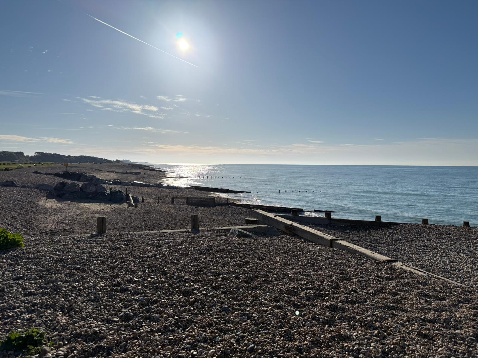 Pebble beach and shimmering sea by the coast.