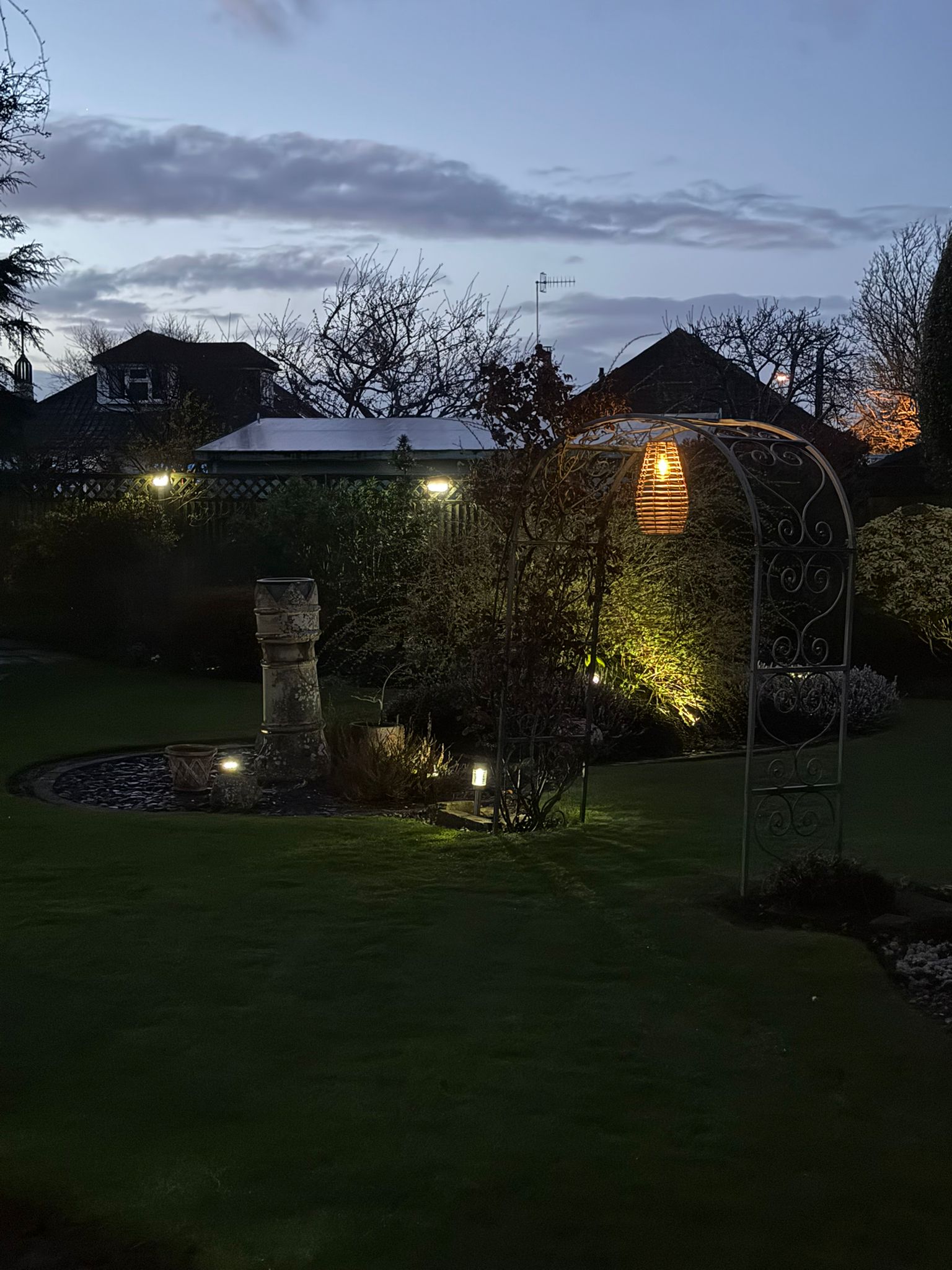 Garden arch and feature fountain at twilight.