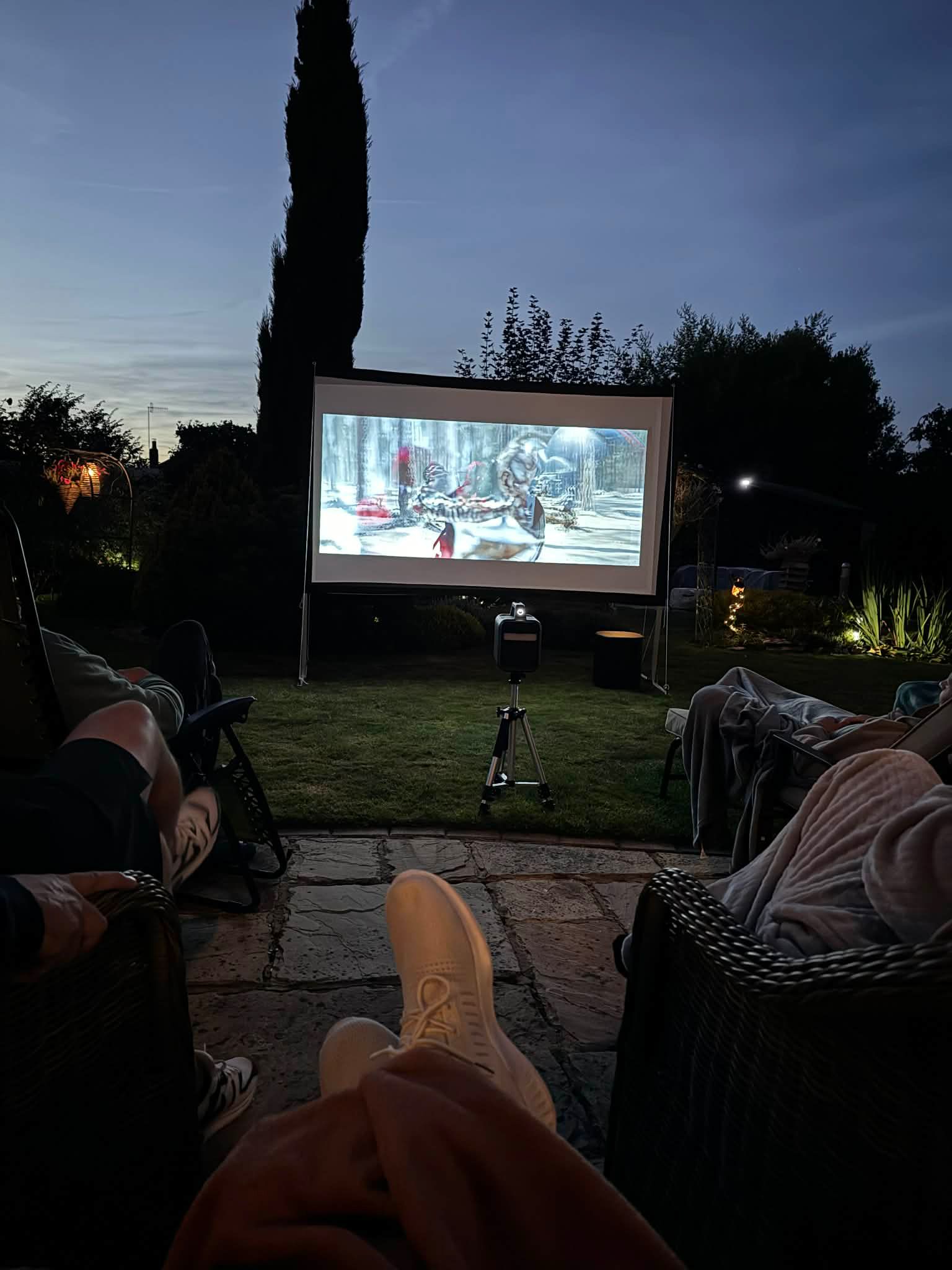 Outdoor cinema setup in the garden at night.